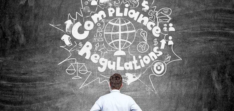 Compliance Regulations Mann steht vor Tafel