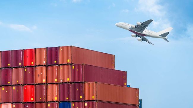 Containerstapel im Hafen mit Flugzeug im Hintergrund