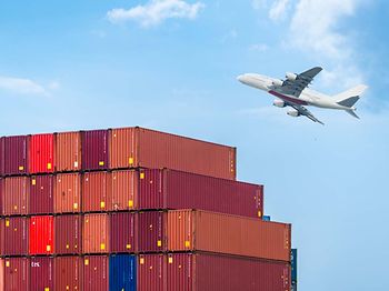 Containerstapel im Hafen mit Flugzeug im Hintergrund