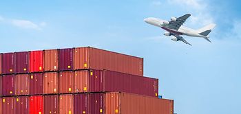 Containerstapel im Hafen mit Flugzeug im Hintergrund