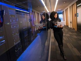 Digitalisierung: Frau lehnt an Serverraum