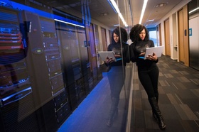 Digitalisierung: Frau lehnt an Serverraum