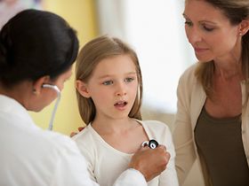 Doctor listening to girl's breathing