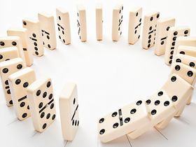 Dominosteine stehen im Kreis, fallen um
