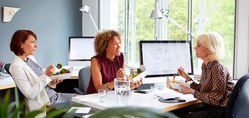 Drei Frauen beim Essen im Büro