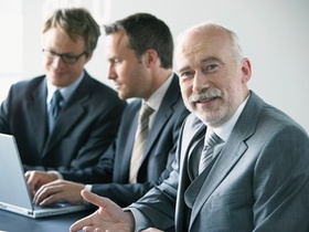 Drei Geschäftsmänner mit Laptop