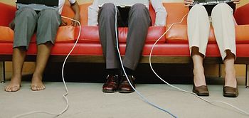 Drei Personen auf Sofa mit Laptop