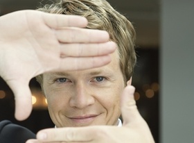 Durchblick, Mann hält Hände als Rechteckt vor das Gesicht