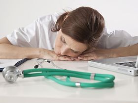 Eine müde Ärztin vor ihrem Computer