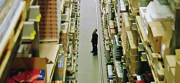 einzelner Arbeiter in riesigem Lager