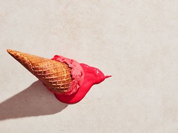 Erdbeereis mit Waffelkegel auf den Boden gefallen