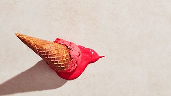 Erdbeereis mit Waffelkegel auf den Boden gefallen
