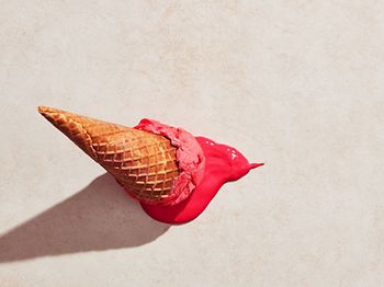 Erdbeereis mit Waffelkegel auf den Boden gefallen