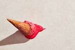 Erdbeereis mit Waffelkegel auf den Boden gefallen
