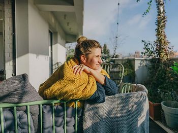 Feiertage_langes Wochenende_Frau_auf_Balkon