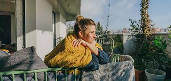 Feiertage_langes Wochenende_Frau_auf_Balkon