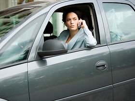 Frau am Steuer mit Handy