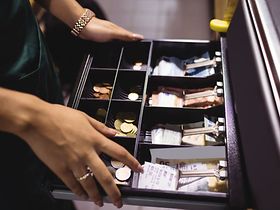 Frau an geöffneter Kasse