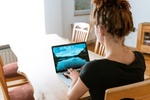 Frau arbeitet am Wohnzimmertisch mit Laptop