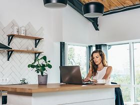 Frau arbeitet im Homeoffice in der Küche