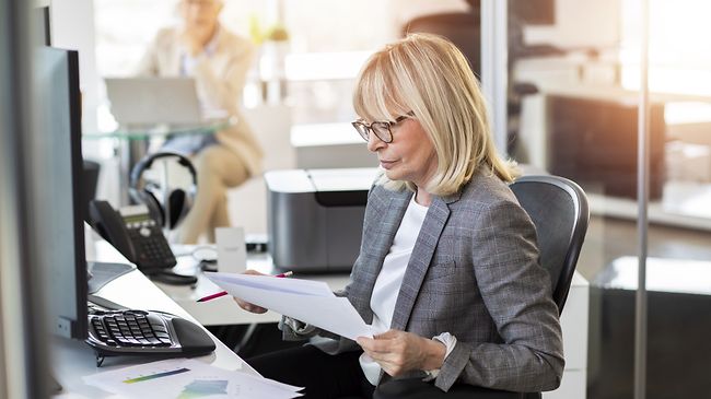 frau arbeitet in lichtdurchflutetem buero mit Anträgen