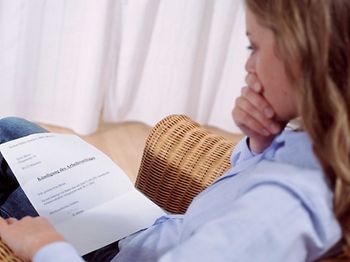 Frau blickt schockiert auf Kündigung des Arbeitsvertrags