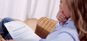 Frau blickt schockiert auf Kündigung des Arbeitsvertrags