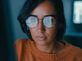 Frau Brille mit Spiegelung am Computer