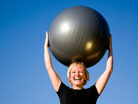 Frau, die Pezzi-Ball über dem Kopf hält
