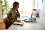 Woman following online courses on her laptop at home.