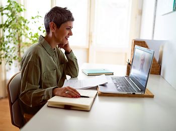 Frau die vorm Laptop sitzt