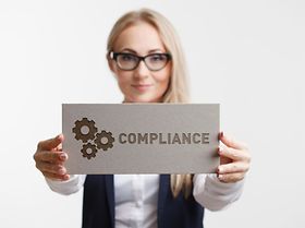 Frau hält Compliance Schild in die Kamera