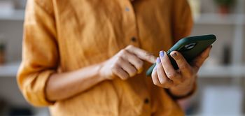 Frau im gelben Tshirt tippt aufs Handy
