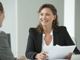 Frau lächelnd bei Bewerbungsgespräch