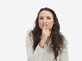 Frau legt Finger auf den Mund - schweigen