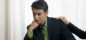 Frau legt Mann Hand auf die Schulter