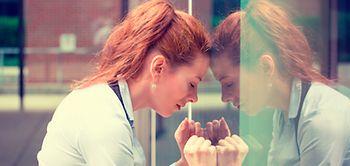 Frau lehnt an Fenster