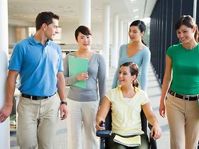 Frau mit Behinderung auf dem Gang mit Kollegen