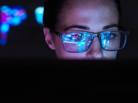 Frau mit Brille vor PC Künstliche Intelligenz
