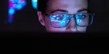 Frau mit Brille vor PC Künstliche Intelligenz