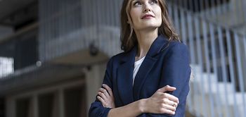 Frau mit eingeschränkten Armen schaut aus dem Fenster