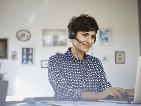 Frau mit Headset im Homeoffice