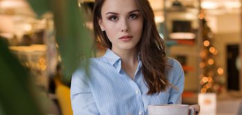 Frau mit Kaffee an Tisch