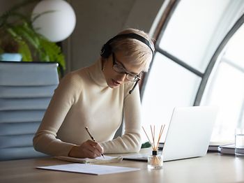 Frau mit Kopfhörern arbeiten
