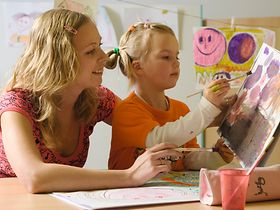 Frau mit Mädchen beim Malen mit Wasserfarben