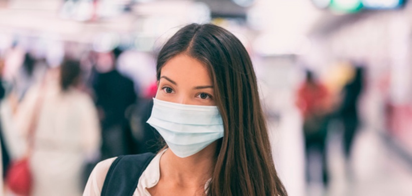 Coronavirus corona virus Asian woman wearing flu mask walking on work commute in public space transp