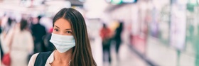 Coronavirus corona virus Asian woman wearing flu mask walking on work commute in public space transp