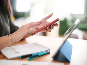 Frau mit roten Handy am tippen