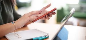 Frau mit roten Handy am tippen