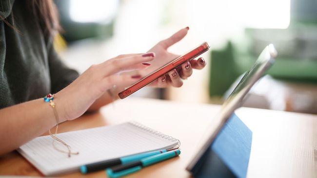 Frau mit roten Handy am tippen